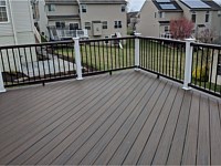 <b>Trex Transcend Spiced Rum Decking installed in diagonal pattern with Trex Vintage Lantern Top and Bottom Handrail with Black Round Aluminum Balusters and White Vinyl Posts</b>